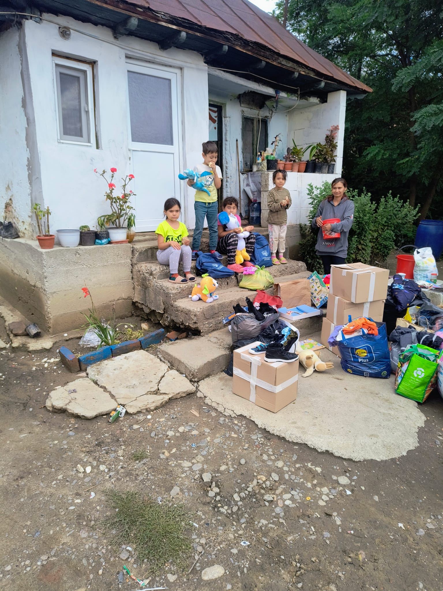 Familie la ușa casei care a primit o mulțime de haine și ajutoare de la asociația Cataleya/Yris