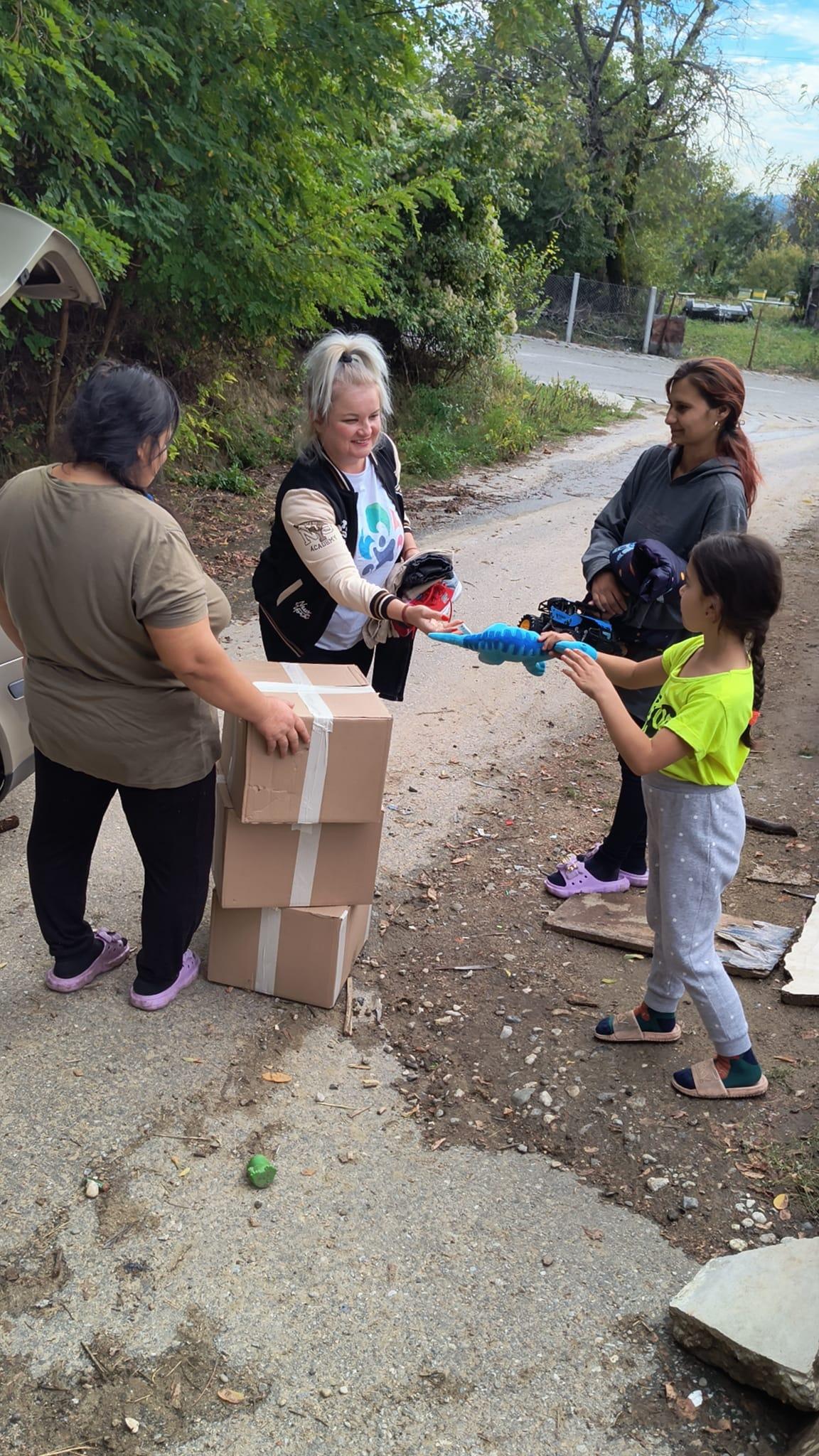 Voluntarii asociației Cataleya/Yris împărțing jucării unei familii.
